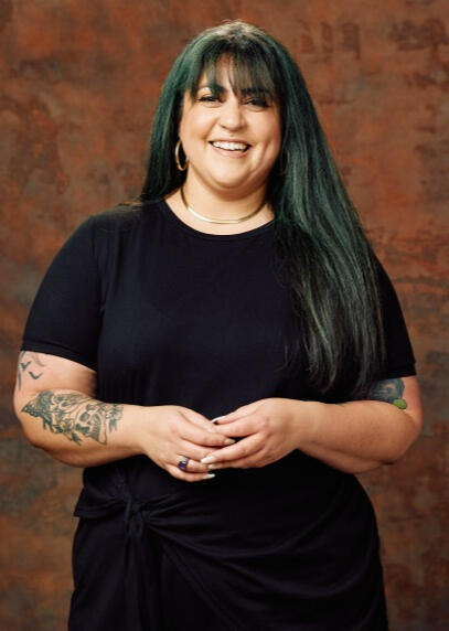 rachel-flores-headshot headshot of rachel flores in a short sleeved black dress with gold jewelry